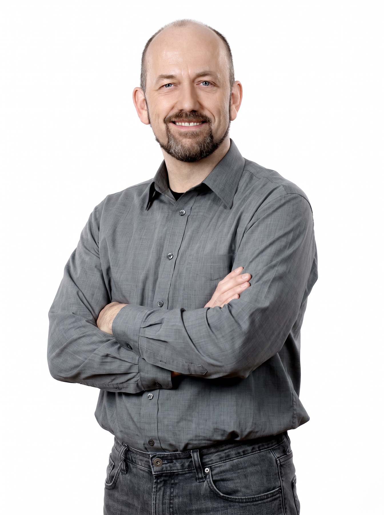 Tobias Weustenfeld lächelt mit verschränkten Armen in die Kamera.